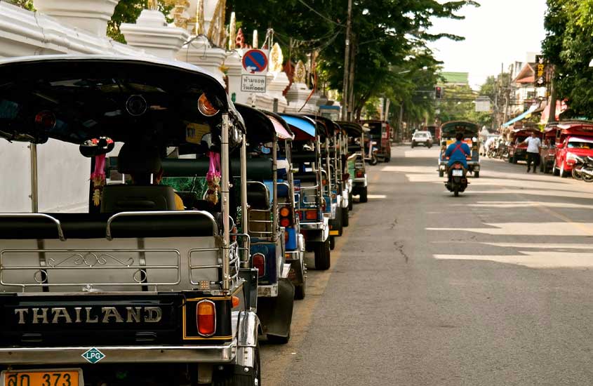 tuk tuks estacionados em rua de Bangkok