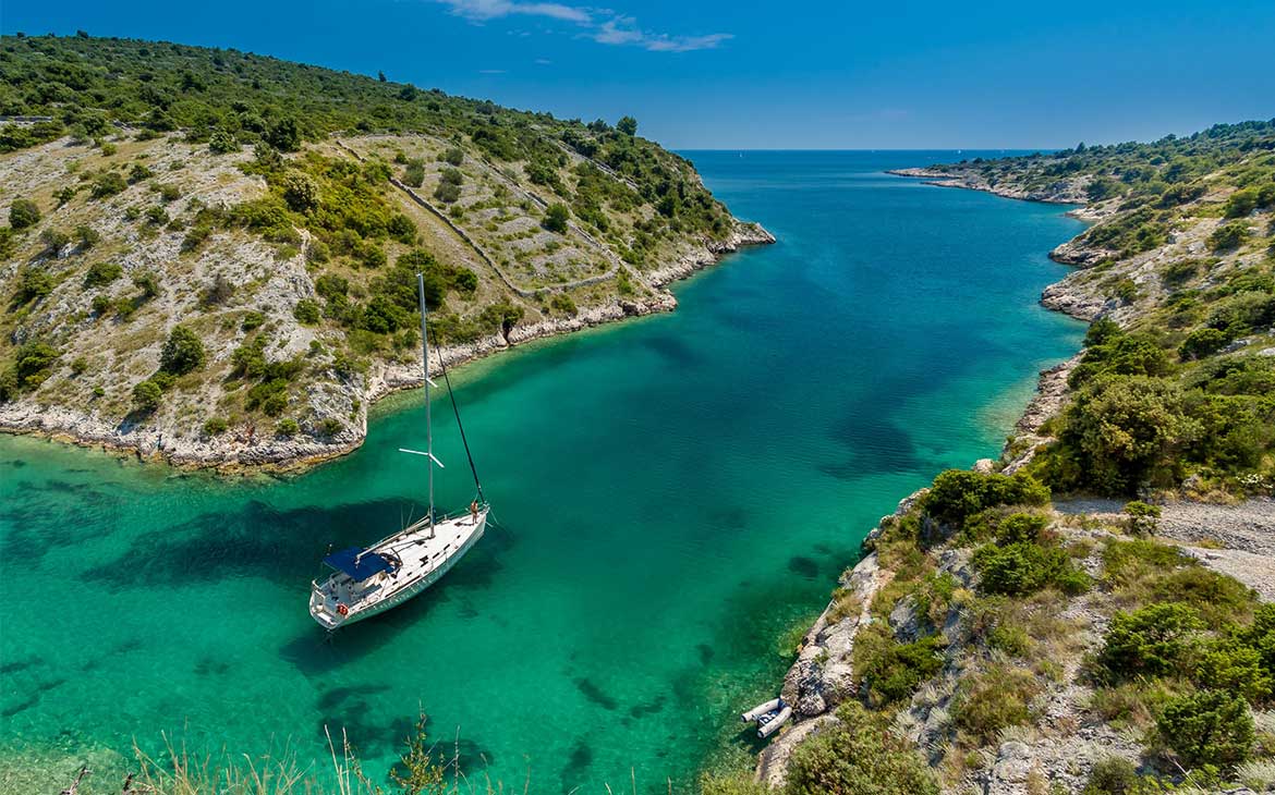 vista aérea de pessoas passeando em barco em águas cristalinas, uma opção para quem busca O que fazer na Croácia