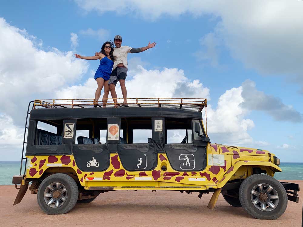 Bárbara Rocha e Vagner Alcantelado sorriem em cima de Jeep 4x4 amarelo