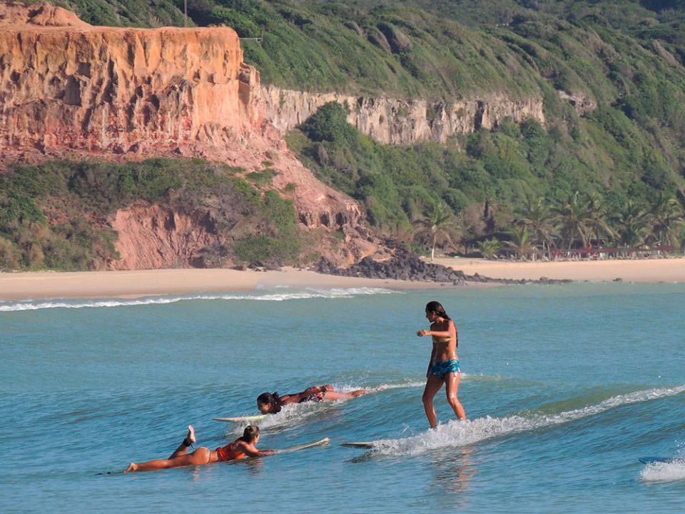mulheres surfam em Praia do Madeiro em Pipa, durante o dia