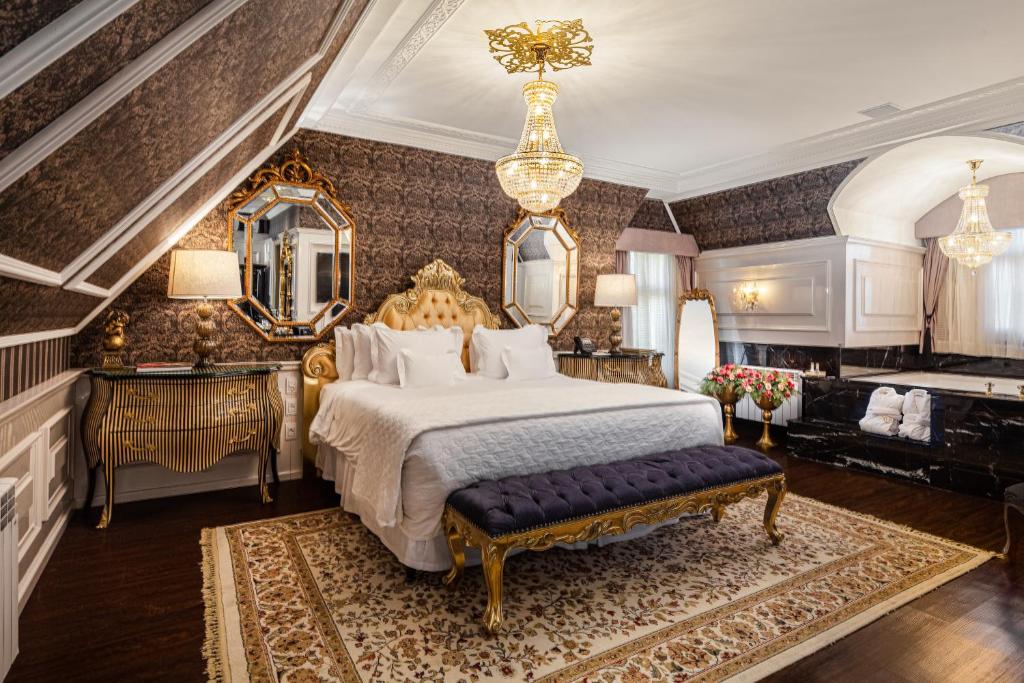 cama de casal, cômoda e banheira de hidromassagem em quarto luxuoso de hotel colline de france