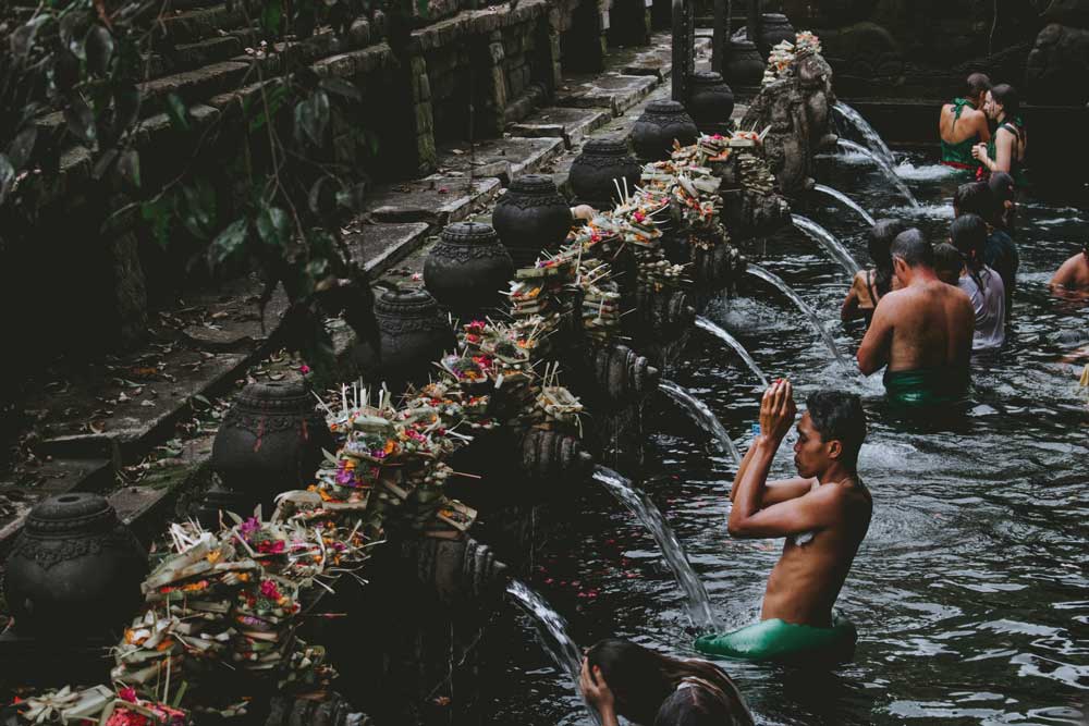 viajantes se banham nas águas sagradas de Tirta Empul, um dos melhores atrativos para quem busca o que fazer na ilha de bali