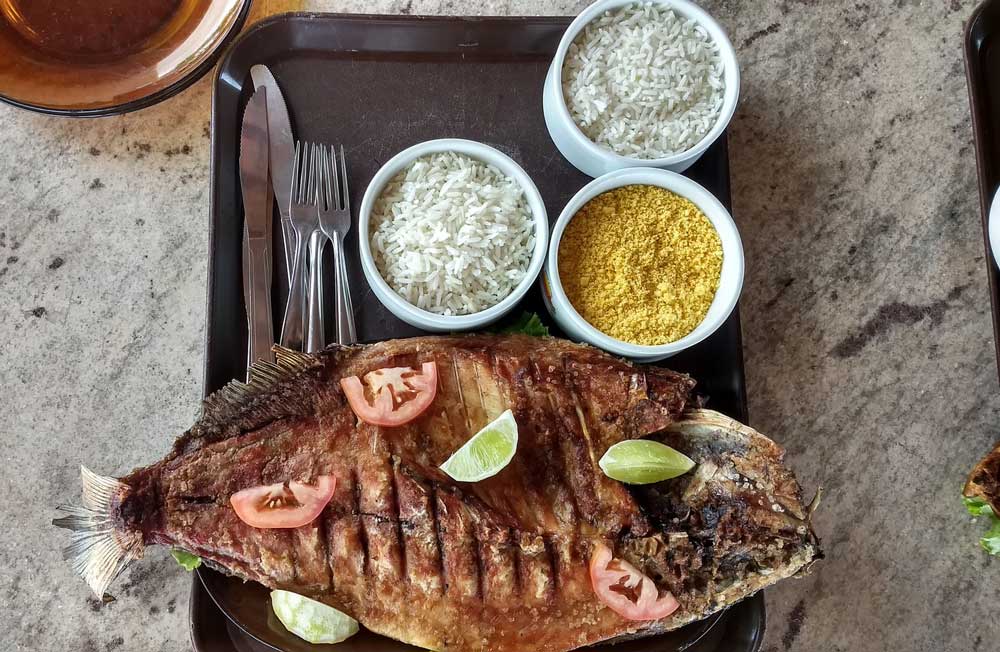 Peixe com tomate, limão, arroz e farofa servido em muitos restaurantes em Fernando de Noronha