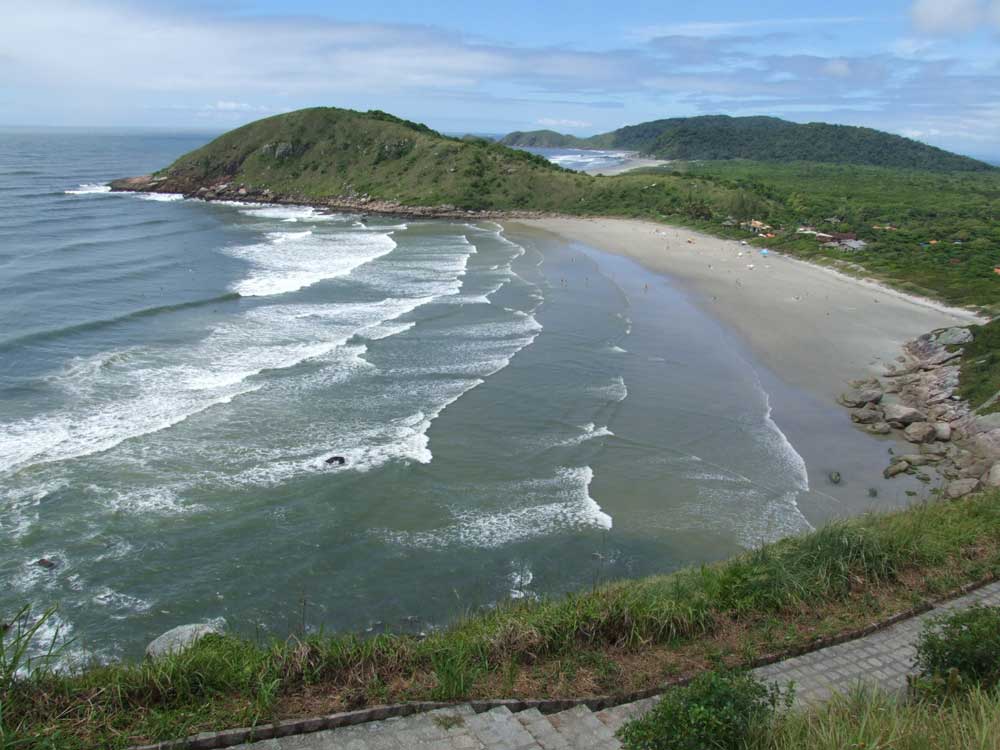 Vista aérea de praia e vegetação ao redor em Ilha do Mel no Paraná, um dos lugares para viajar a dois mais sossegados