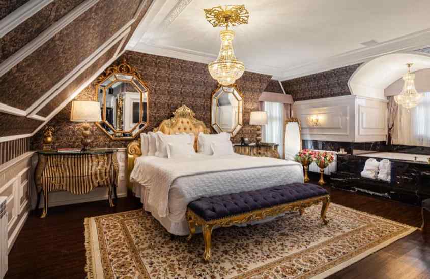 Quarto luxuoso com cama de casal, espelho, luminária, tapete e cortinas ao redor