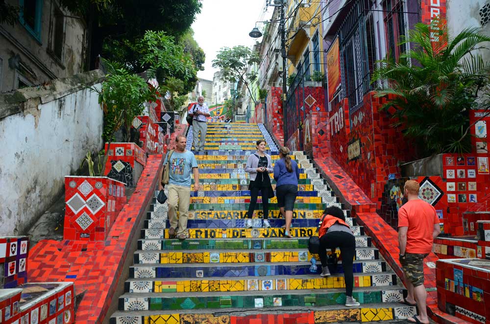 Pessoas conversam, durante o dia, em Escadaria Selarón, uma escada feita com azulejos coloridos, no Centro do Rio de Janeiro