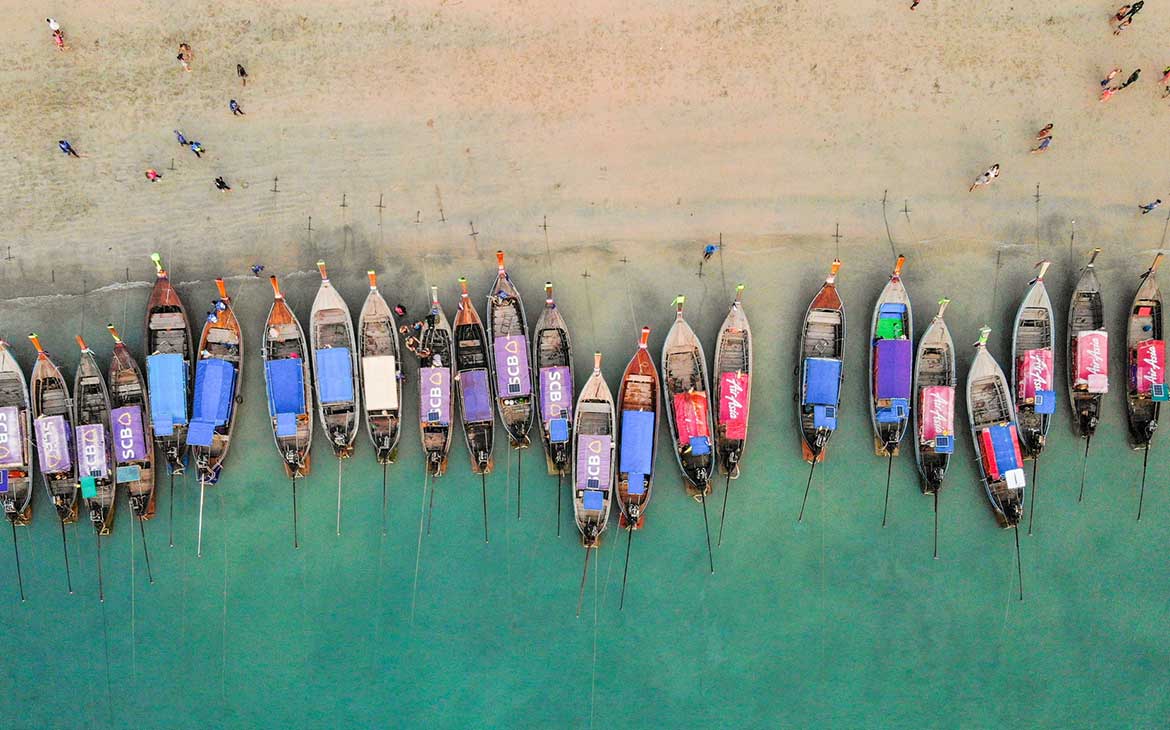 durante o dia, vista área de bancos coloridos ancorados, na praia lugar de turismo na tailandia