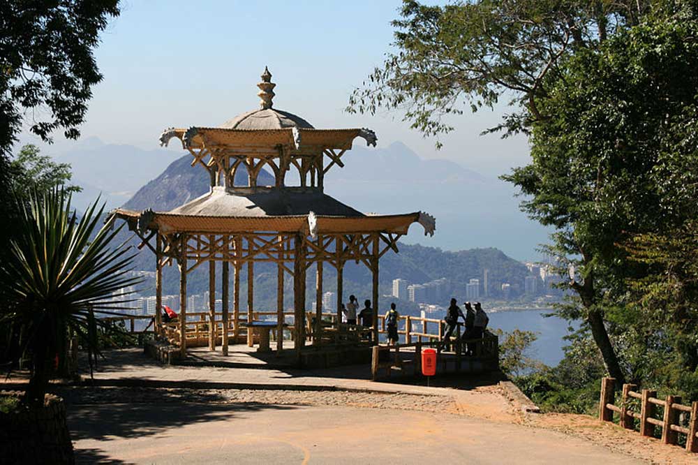 Pessoas ao redor de construção em estilo chinês, um mirante no Rio de Janeiro com vista para o mar