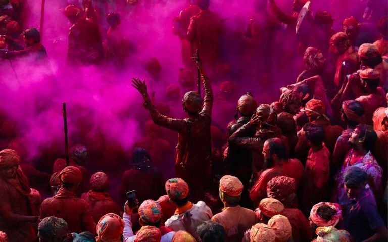 pessoas sujas de tinta roxa em um dos festivais pelo mundo