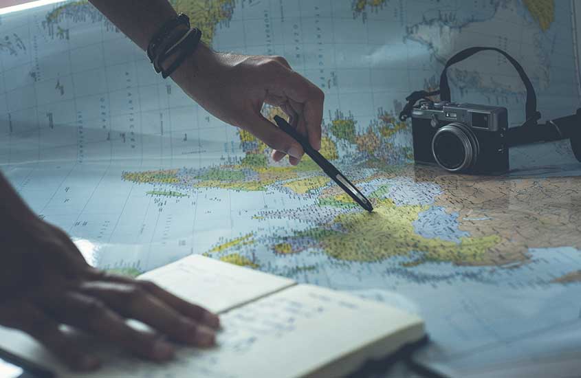 Viajante procura lugares em mapa de papel