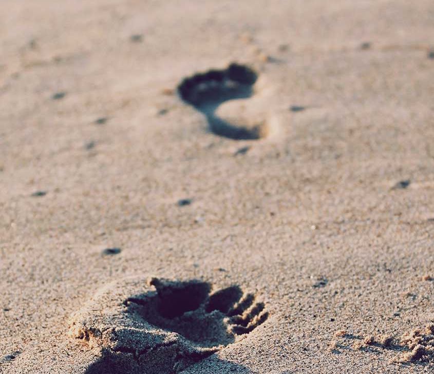 Marcas de pés em areia de praia em Ilha Grande