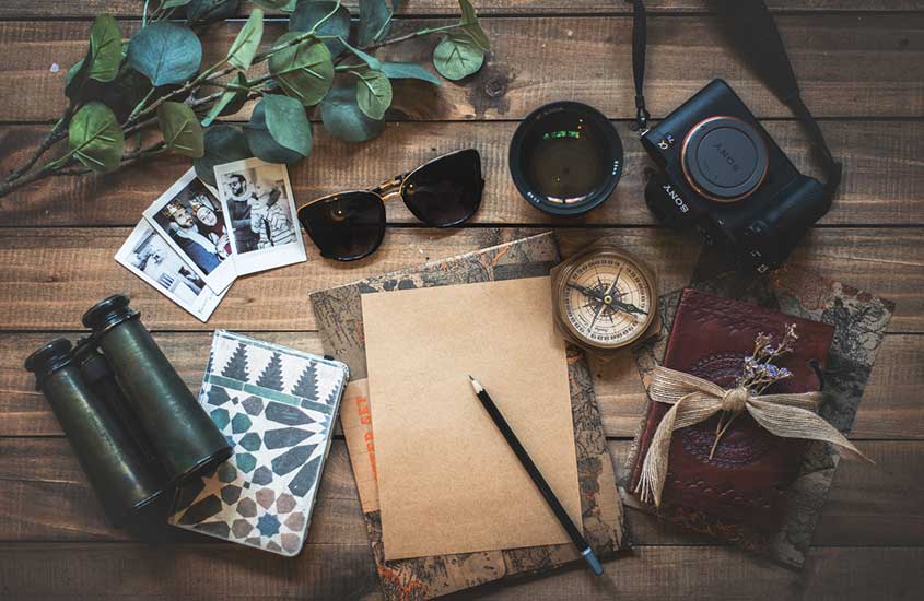 câmera, caderno, fotos, óculos, em cima de mesa de madeira