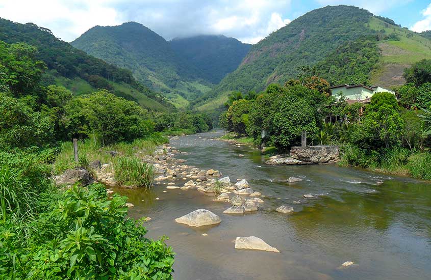Rio entre árvores em Arraial do Sana, um dos lugares para viajar no estado do rio de janeiro