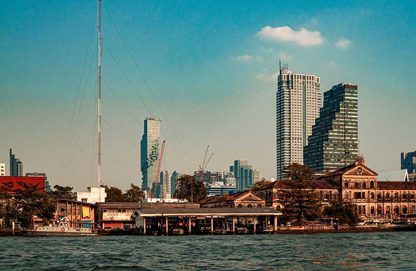 durante o dia, prédios em frente ao rio Chao Phraya, uma área romântica que é uma opção para quem busca onde ficar em Bangkok