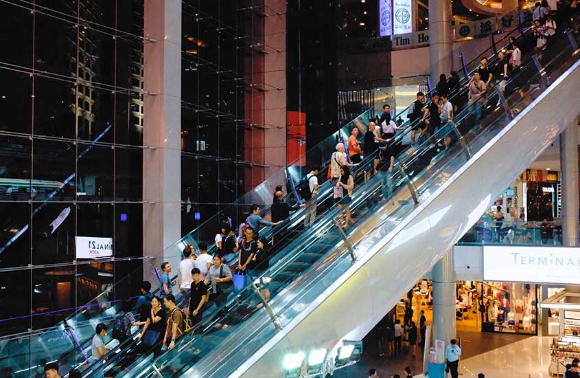 diversas pessoas em escada rolante de shopping no bairro de Pratunam, um lugar onde ficar em Bangkok