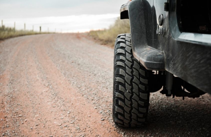 pneu de jeep em estrada de terra durante o dia