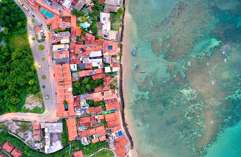 vista aérea de casas, vegetação e praia em morro de são Paulo, durante o dia