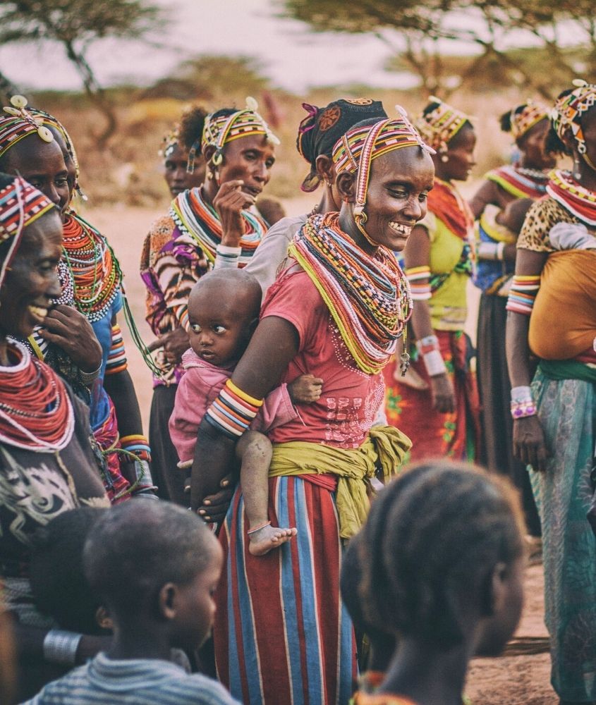Mulheres e crianças vestidos com roupas e acessórios culturais, na Africa