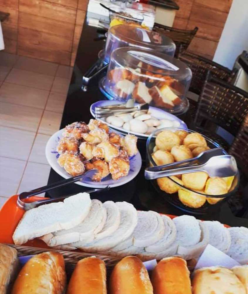 bolos e pães em mesa de café da manhã de pousada bela vista de mateiros, uma das pousadas do jalapão