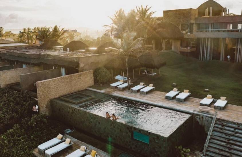 vista aérea de pessoas em piscina durante entardecer em kenoa exclusive beach spa & resort, hotel de luxo em barra de são miguel