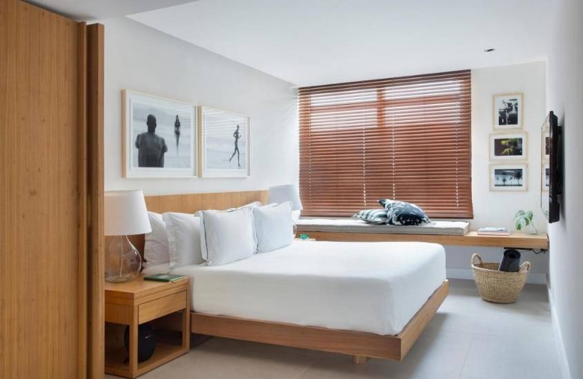cama de casal em quarto com paredes brancas de janeiro hotel, um dos melhores hotéis de luxo no brasil