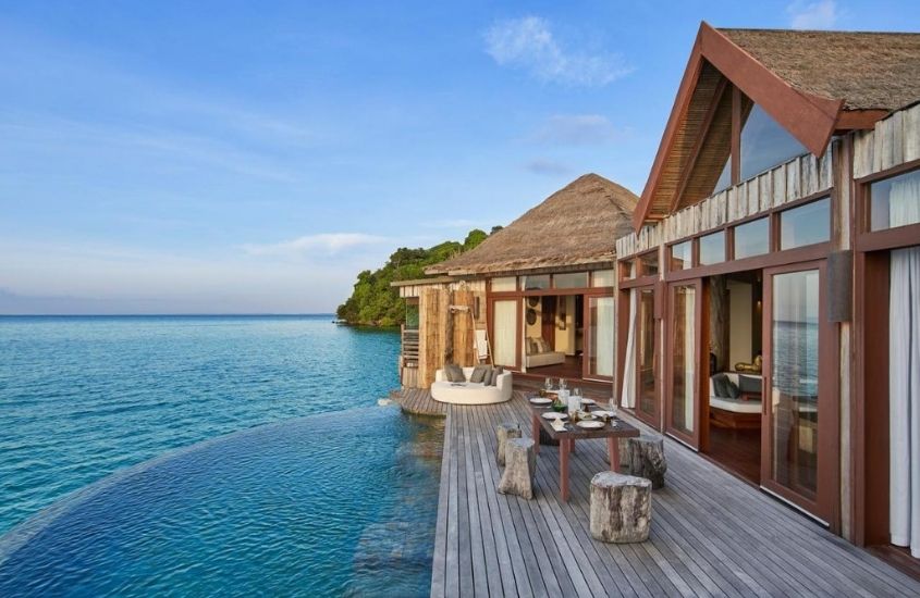 vila com varanda de frente para o mar, durante o dia, em song saa, um dos hotéis mais bonitos do mundo localizado em camboja