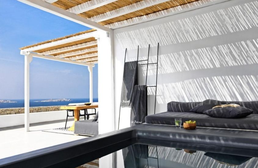 banheira em varanda de frente para o mar, durante o dia, em boheme mykonos town, um dos hotéis mais bonitos do mundo, localizado na grécia