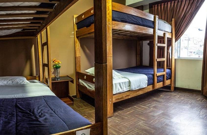 duas beliches de madeira em quarto de tupac hostel, hospedagem no peru, um dos lugares baratos para viajar na america do sul