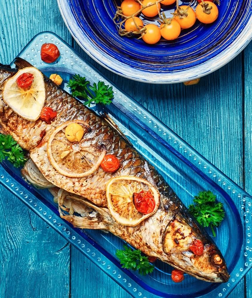 peixe com legumes assados em cima de prato