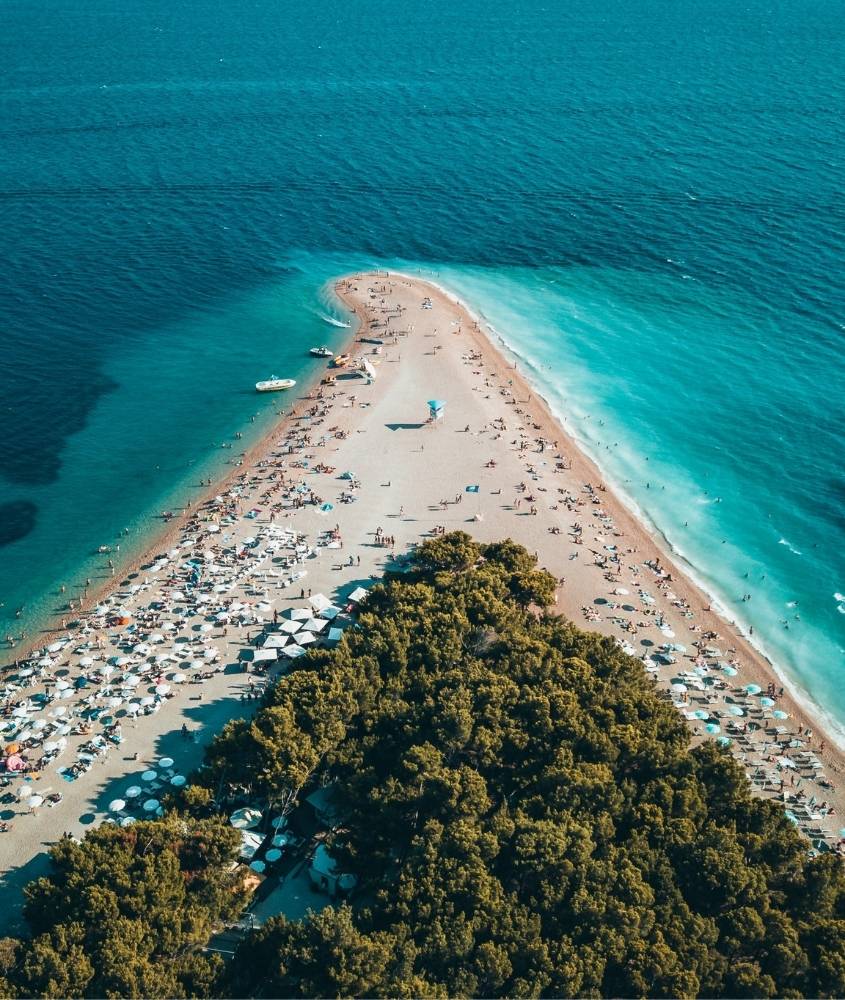 pessoas em faixa de areia em formato de triangulo rodeado pelo mar, durante o dia, na croácia