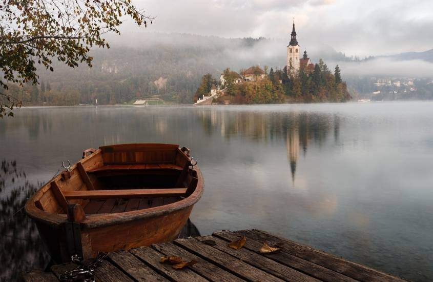 canoa de madeira em lago durante dia nublado na eslovênia, um dos países mais baratos para viajar na europa