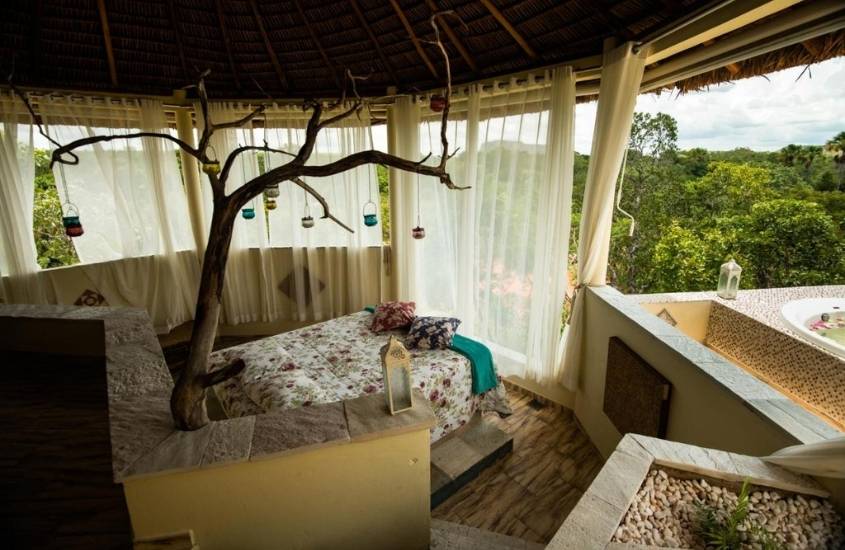 cama de casal em quarto com vista para arvores e montanhas do Jalapão Ecolodge, uma boa opção para quem busca onde ficar no jalapão