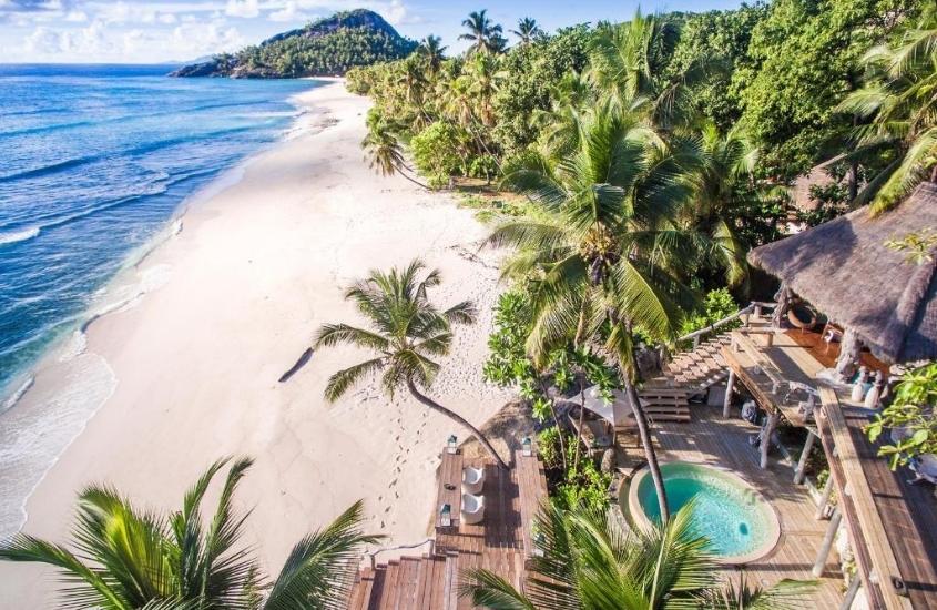 vista aérea de piscina em varanda de north island lodge, hotel mais caro do mundo de frente para a praia em seychelles