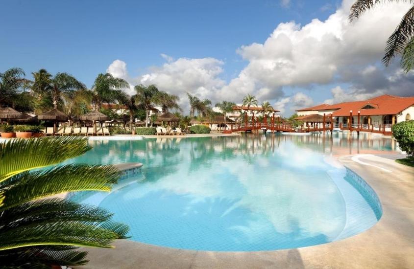 piscina cercada de árvores em grand palladium imbassaí, um dos melhores resorts para família na bahia