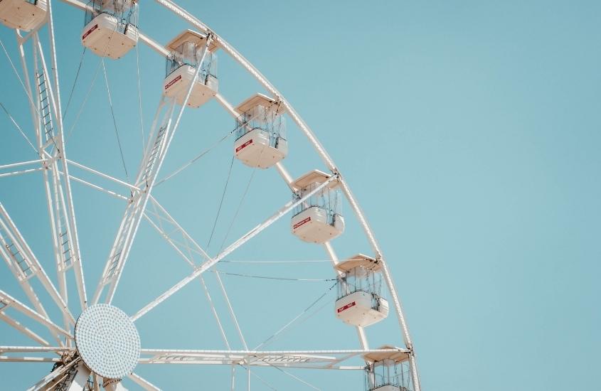 roda gigante branca sob céu azul em parque de diversões guanabara, um atrativo para incluir no seu roteiro belo horizonte
