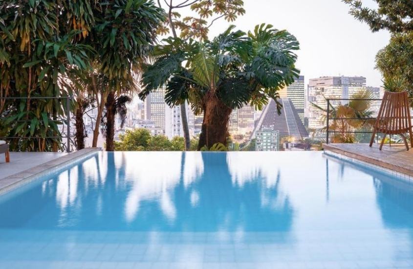 piscina com borda infinita com vista para prédios em casa gerânio, um dos melhores hotéis em santa teresa rj