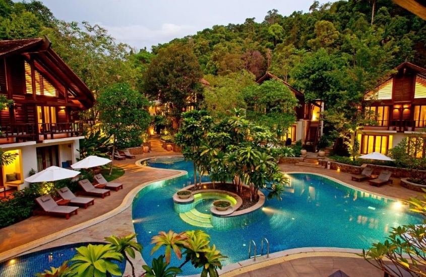 vista aérea de chalés rodeados de árvores em frente a piscinas em the tubkaak krabi boutique, um resort em krabi tailândia