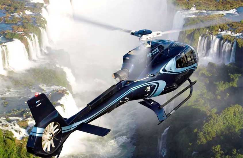 Em um dia de sol, helicóptero sobrevoando as cataratas do iguaçu