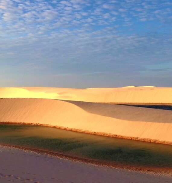 lagoa cercada por dunas, durante o dia, nos lençois maranhenses