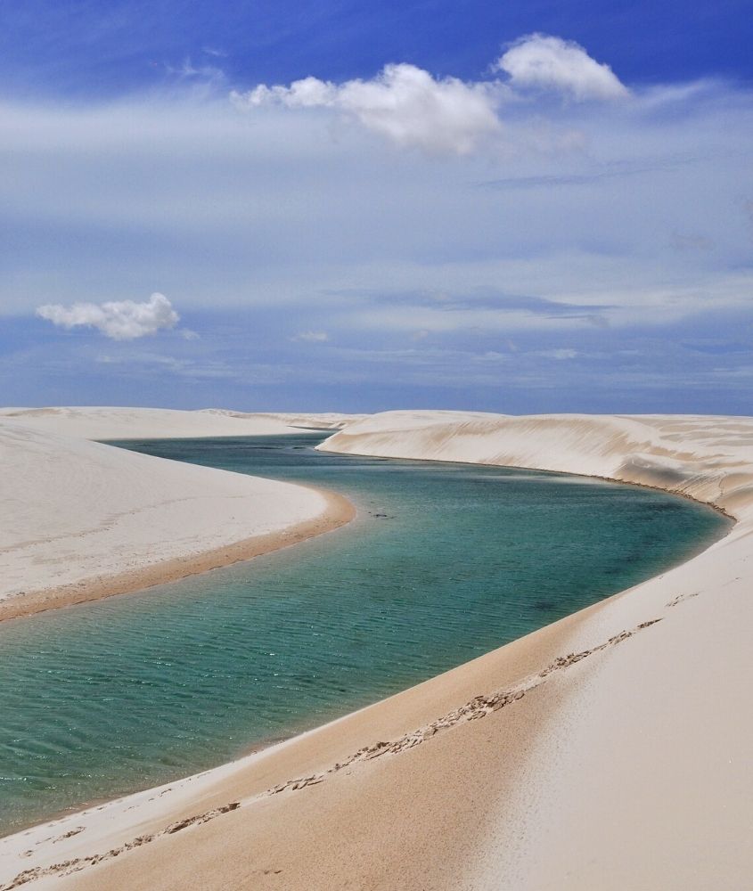 lagoa cercada por dunas, durante o dia, nos lençois maranhenses