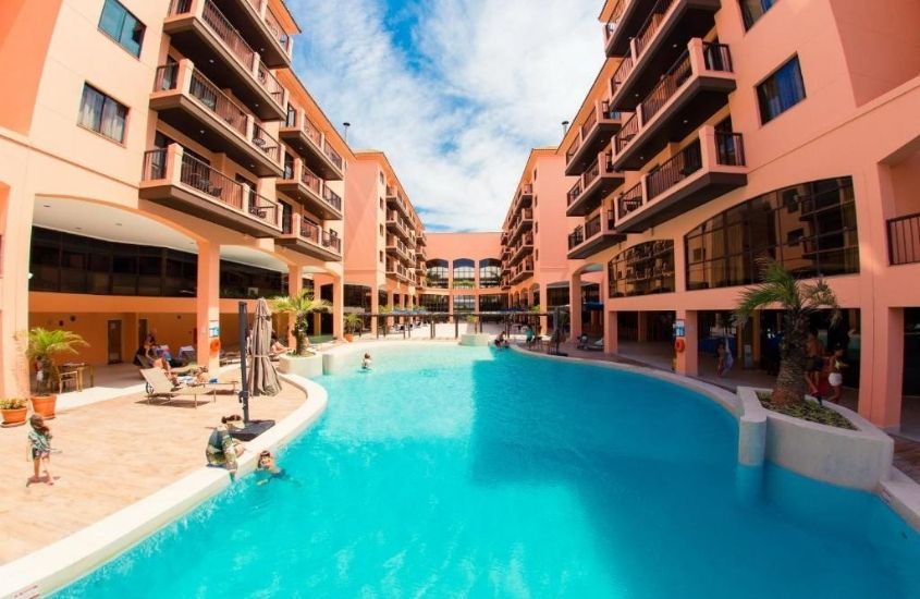 hóspedes tomando banho de piscina, durante o dia, em área de lazer de Jurerê Beach Village, um dos melhores hotéis em Florianópolis