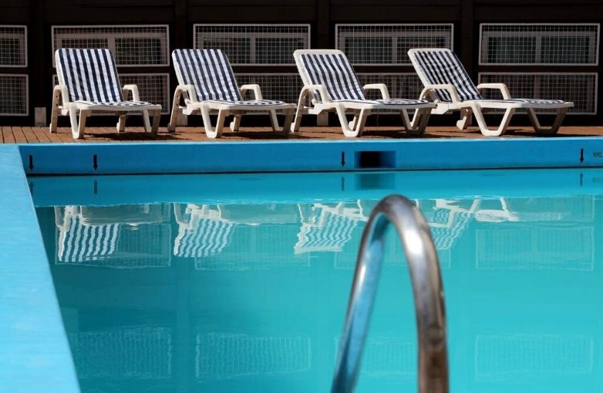 espreguiçadeiras em frente a piscina em área de lazer de Castelmar Hotel, um dos melhores hotéis em Florianópolis