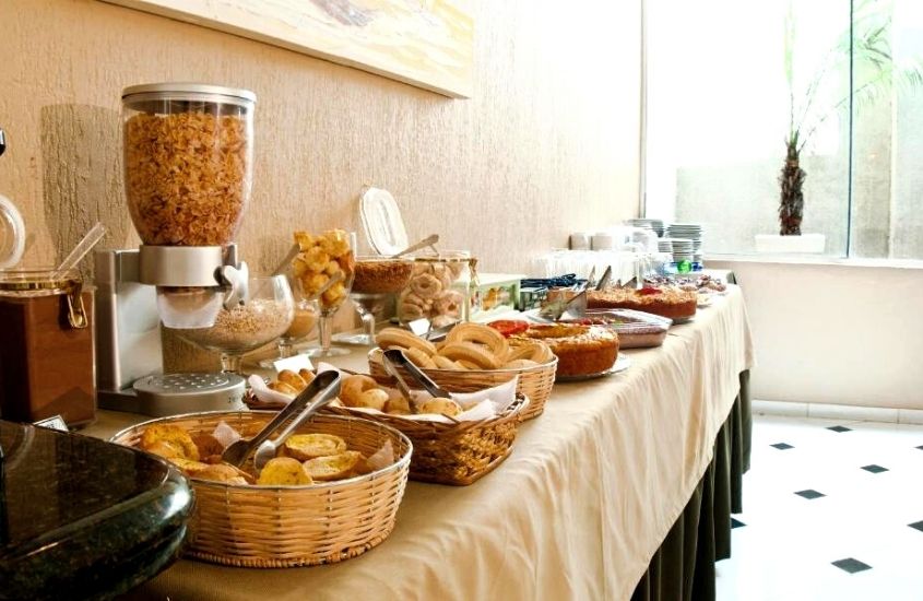 pães e bolos em cima de mesa de café da manhã do Hotel Villa Canoas, uma boa opção para quem busca por pousadas em foz do iguaçu baratas