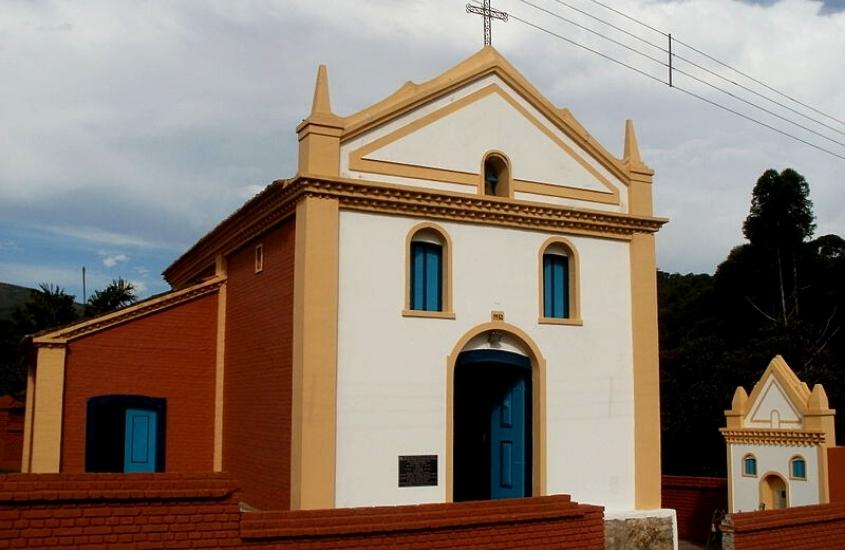 igreja branca, amarela e vermelha conhecida como igreja matriz de ibitipoca, em dia nublado em ibitipoca, minas gerais