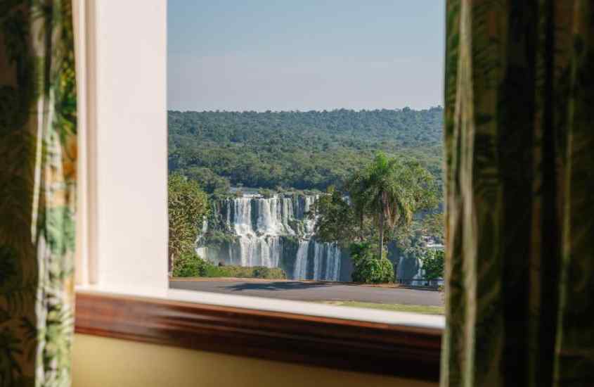 Janela acortinada com paisagem das cataratas e para Pizzas e focaccias do Pátio Pomare, uma opção gostosa para inserir no seu roteiro Foz do Iguaçu
