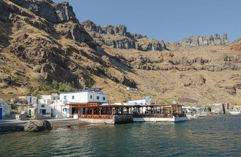montanhas e casas de frente para o mar, durante dia ensolarado em ilha de thirassia, um dos pontos turísticos de santorini