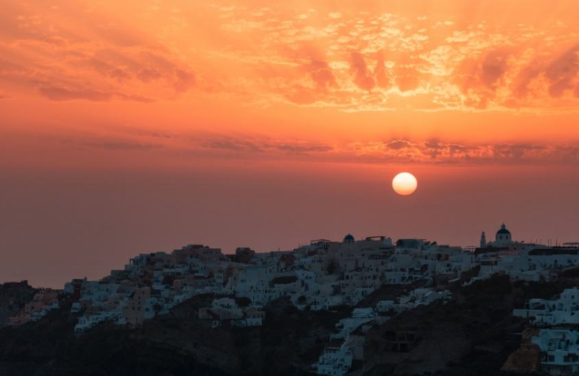 vista aérea de casas brancas durante pôr do sol em santorini