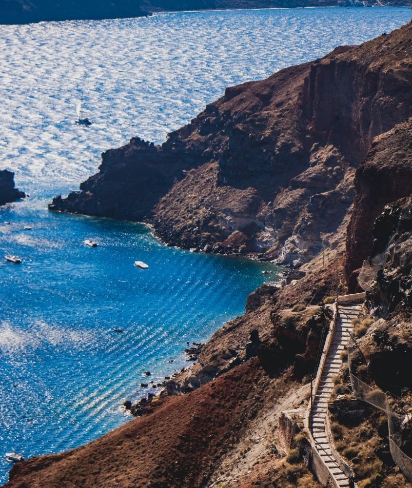 vista aérea de escadas de trilha em montanha de frente para o mar, durante o dia na grécia