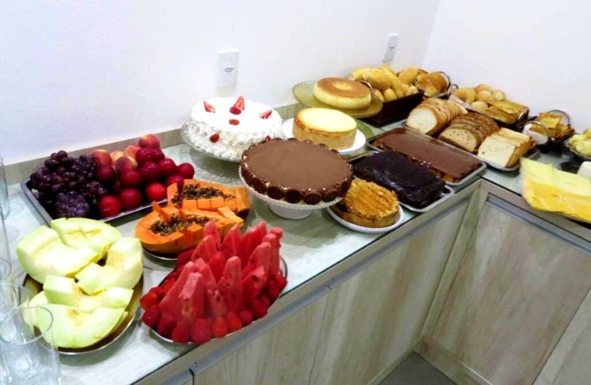 frutas, bolos e pães em mesa de café da manhã da Pousada Vó Dena, o hotel mais perto do beto carrero world