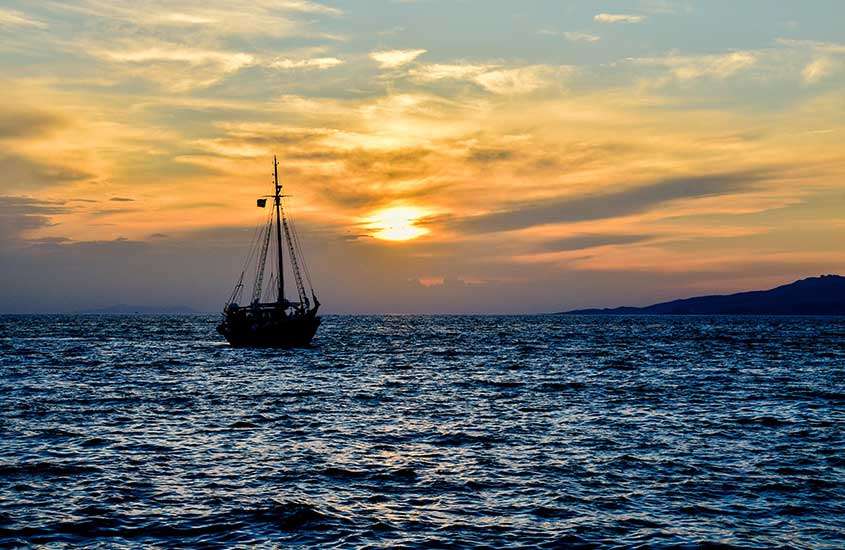 durante entardecer, barco em mar de praia em Mykonos